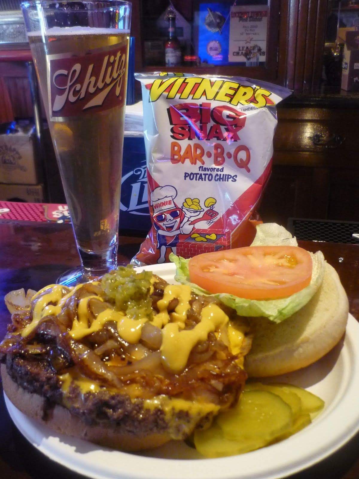 Nick's burger with a bag of bbq chips and a cup of beer. 