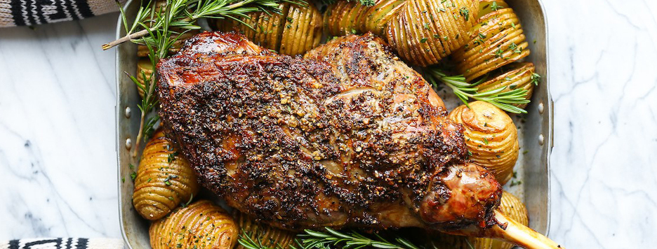 a roasted chicken with cut up roaster potatoes surround it 