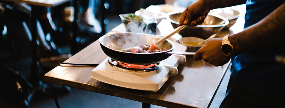 a chef cooking food in a skillet 