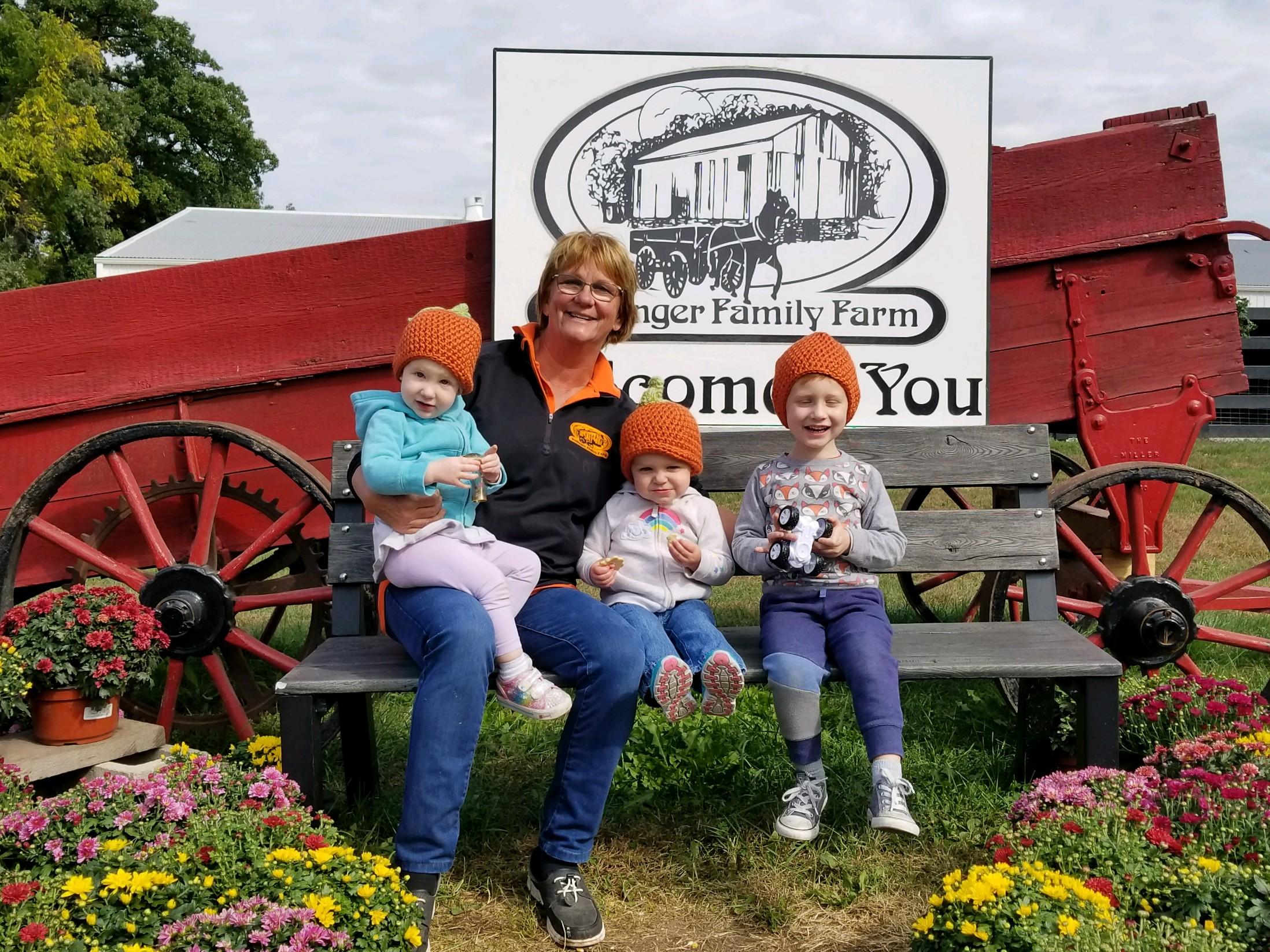 Noreen Dollinger with her three grandchildren in from of their welcome sign