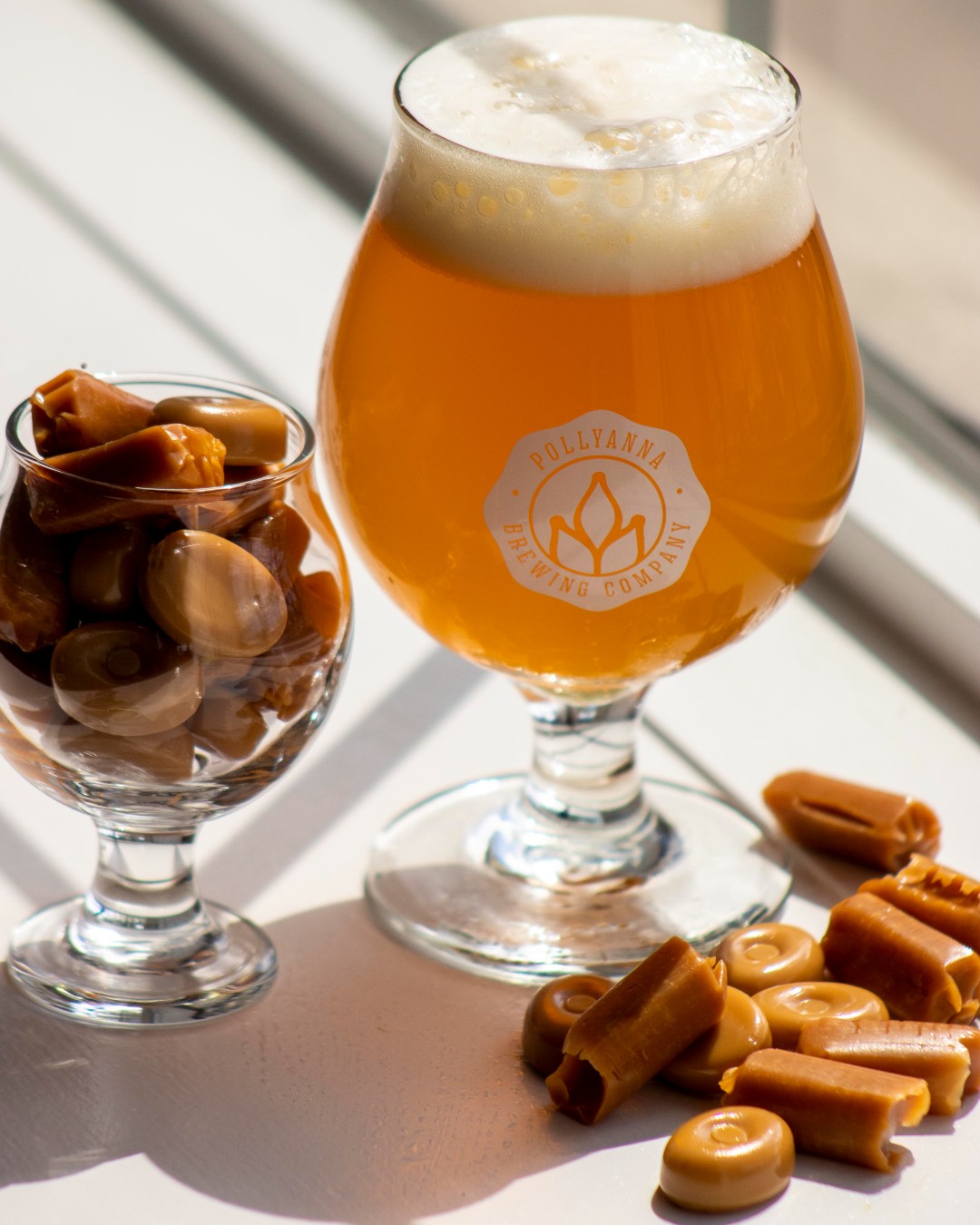Glass of Pollyanna beer surrounded by caramel candies