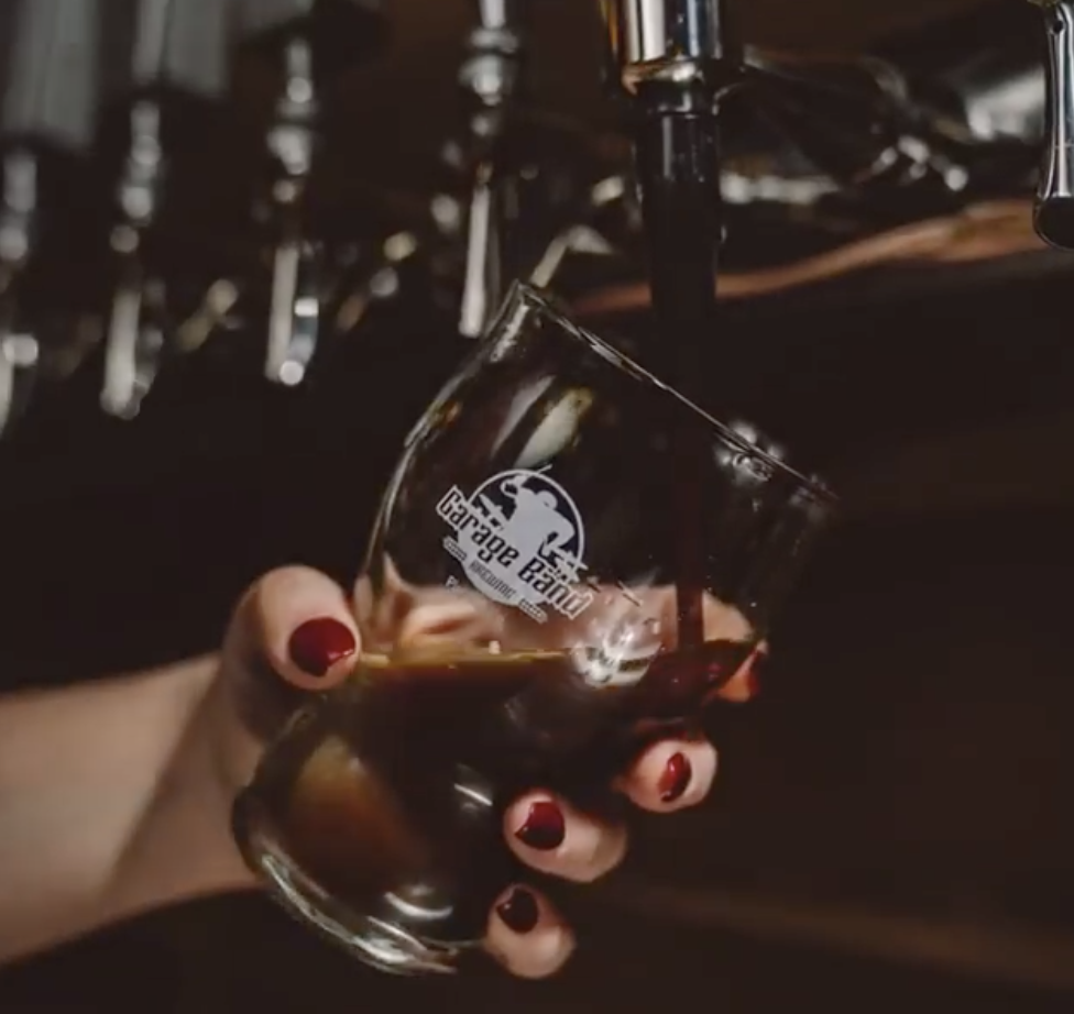Beer flowing from a tap into a glass at Garage Band Brewing