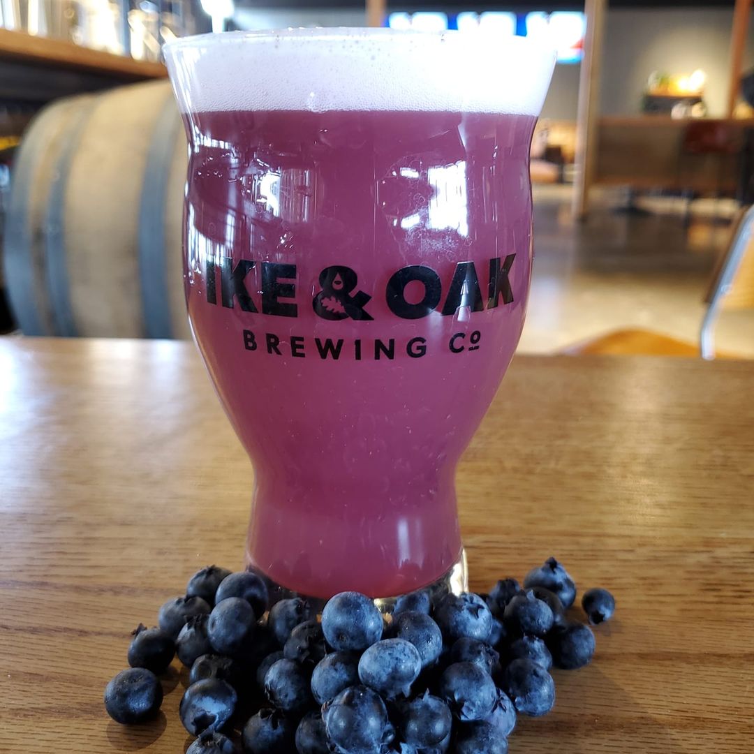 Tall glass of Woolly Harbor from Ike & Oak, surrounded by blueberries