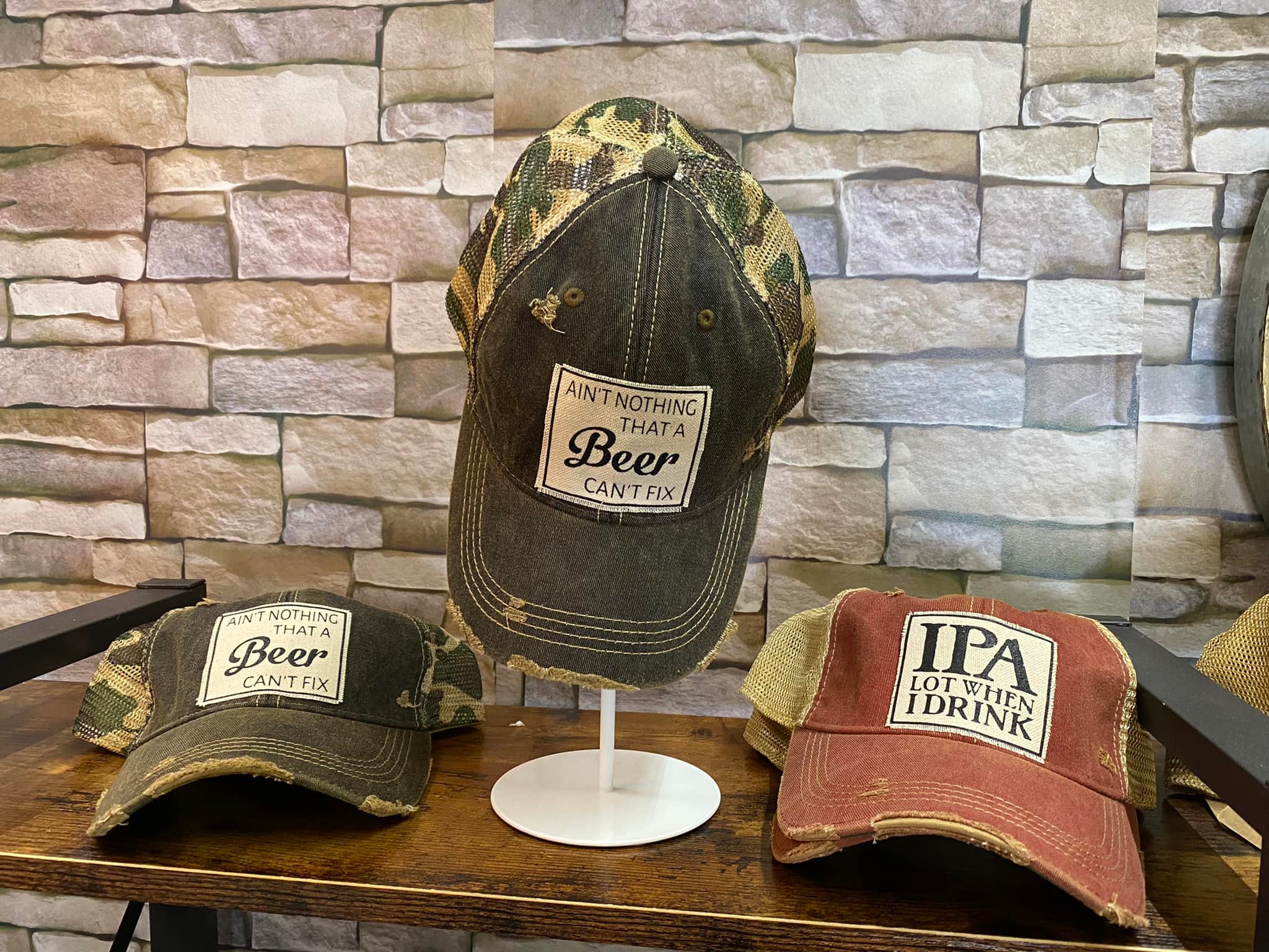 3 baseball caps that have beer sayings on them